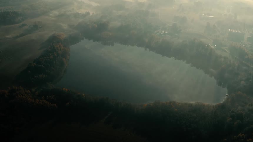 The lake sits near the farm on a foggy day