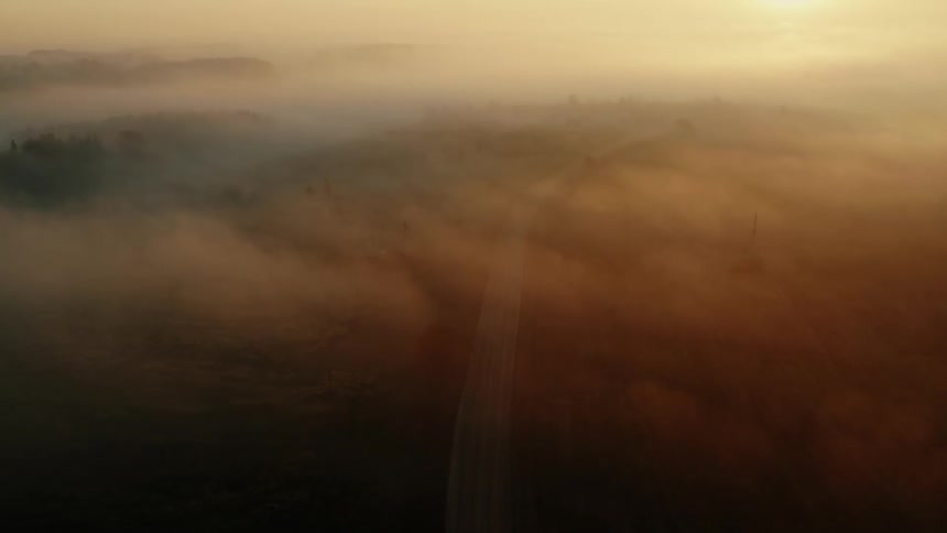 Dense clouds and thick fog cover a highway