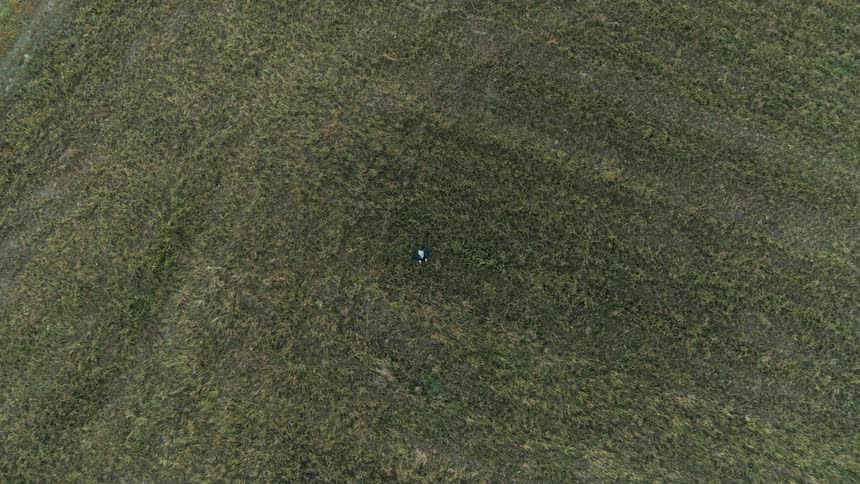 A child flying a drone in a large field