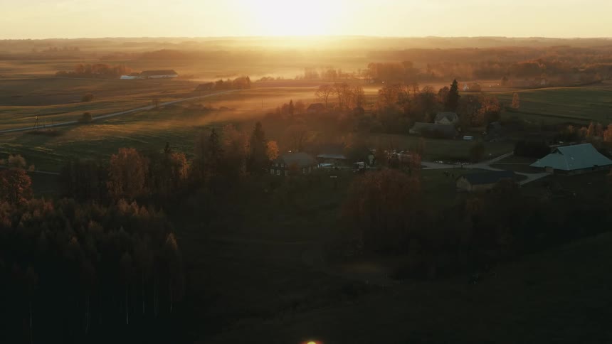 An aerial view of rural homes outside at sunset