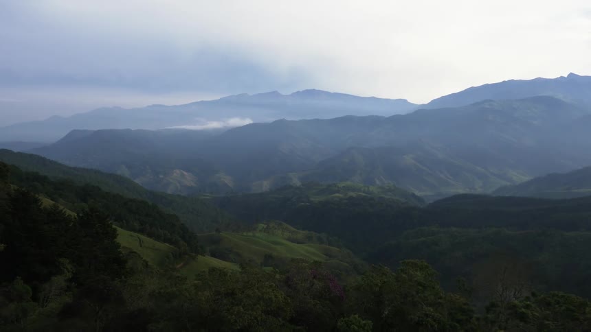 An aerial view of hills covered in grass and trees