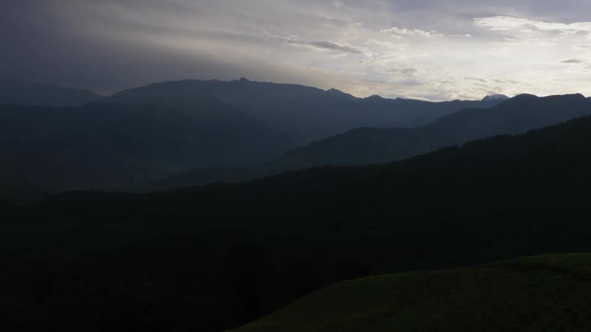Aerial view of range of mountains with silhouette at dusk