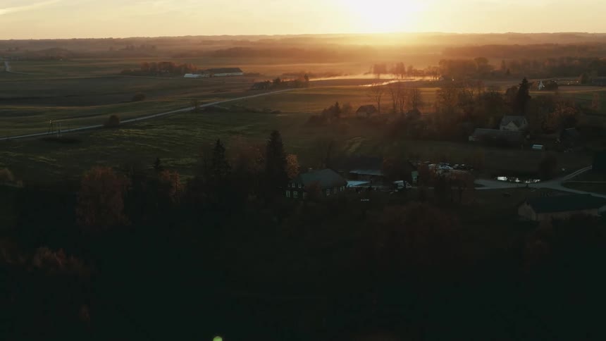 An aerial view of rural homes outside at sunset