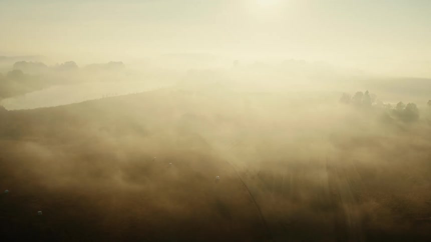 An aerial view of a lake in nature on a foggy day