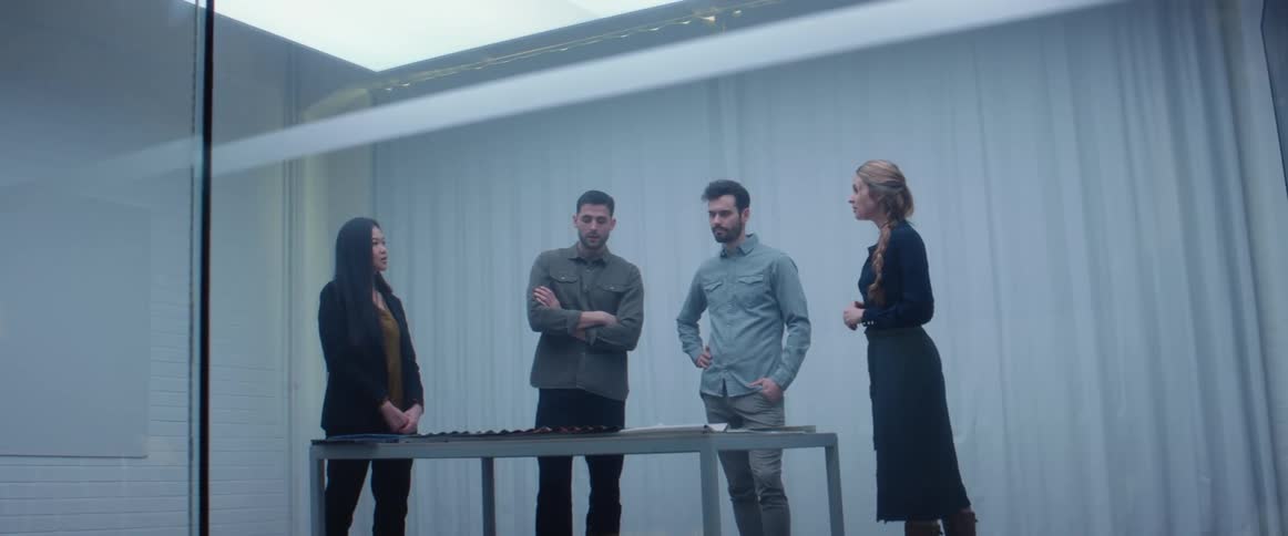 Group of people standing on a meeting room inside an office looking at samples