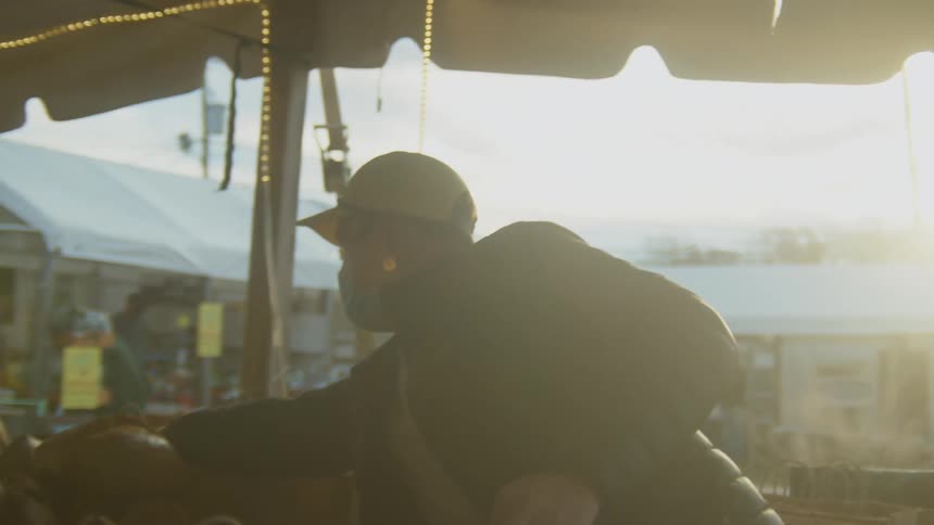 Baker selling bread in an outdoors market in the morning