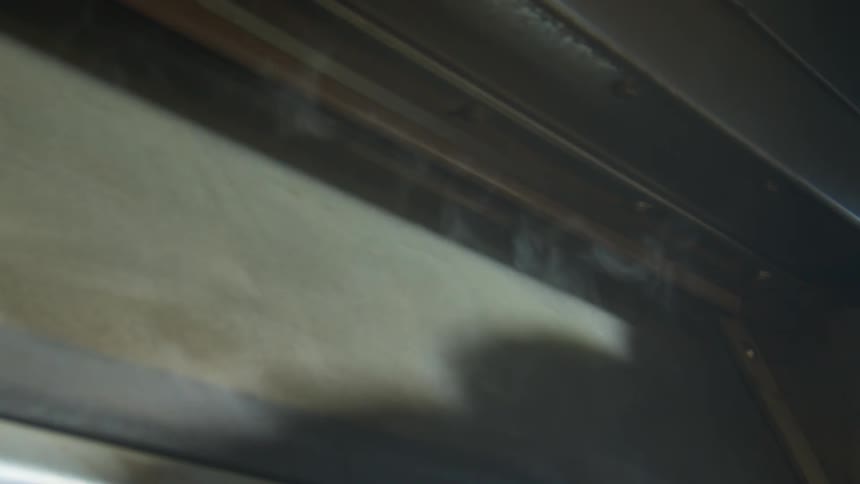 Smoke rises from cream colored surface and corner of dark brown enclosing surface