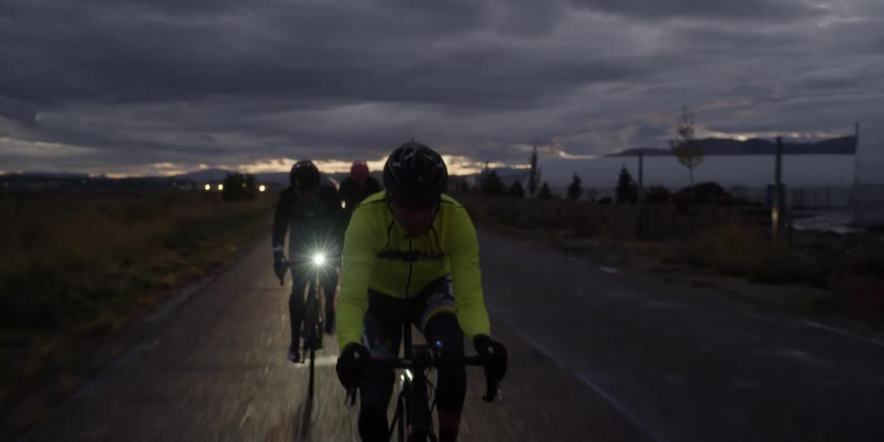 A group of people riding bikes at sunset