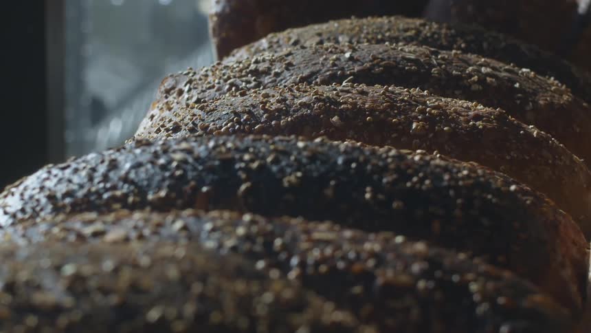 Loaves of bread bake in an oven during the day