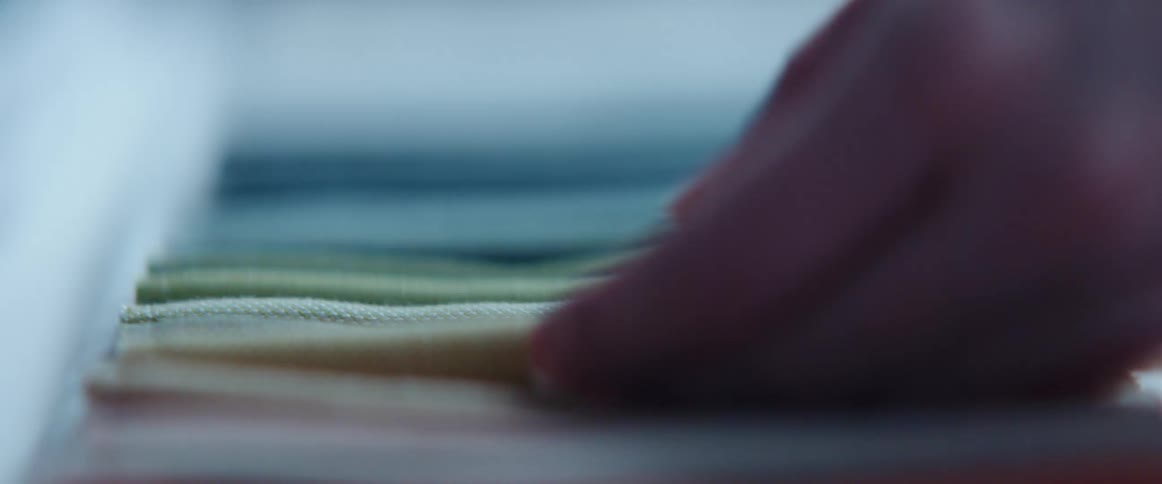 Customer testing carpet samples over a desk in a meeting room