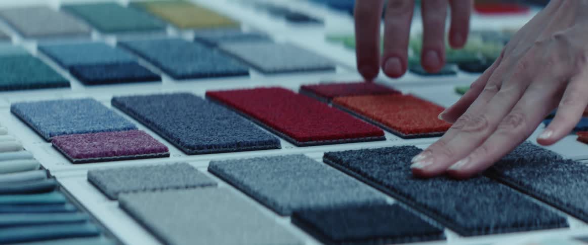 Customer testing carpet samples over a desk in a meeting room