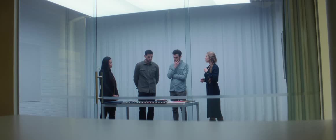 Group of people standing on a meeting room inside an office looking at samples