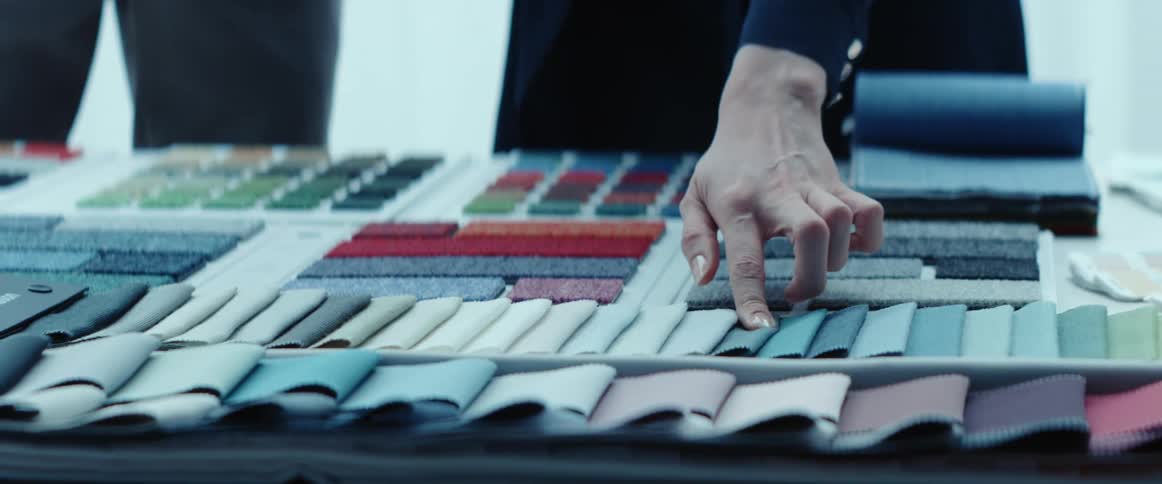 A woman touching fabrics on a table