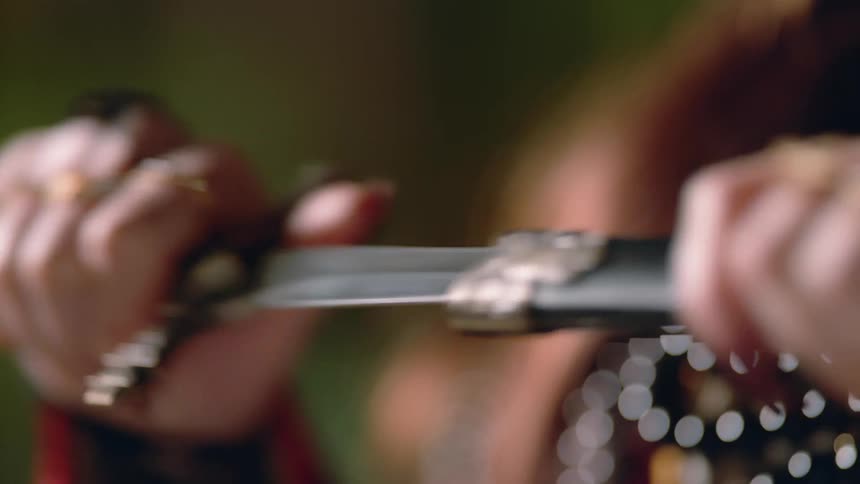 A woman pulls a knife out of a case