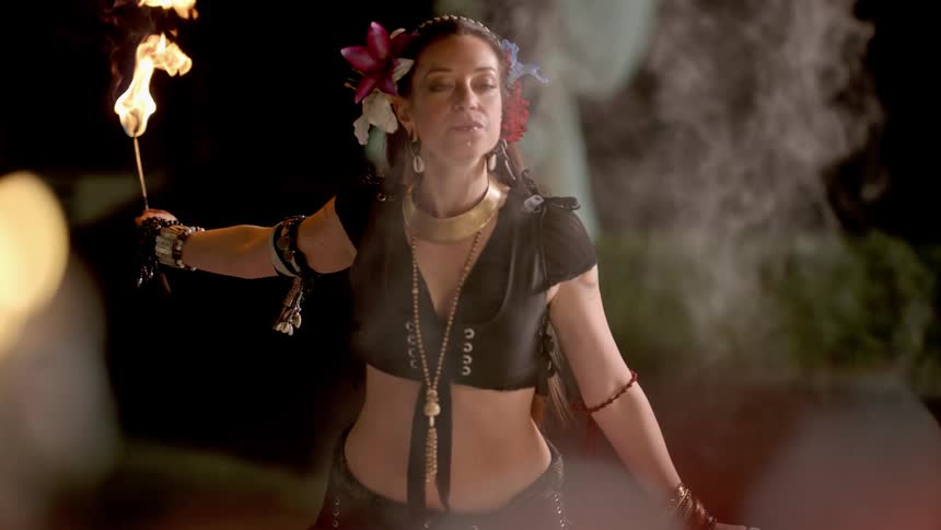 Female fire dancer creates a fireball with her mouth