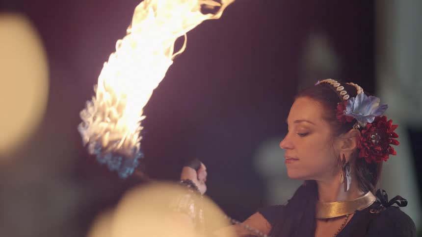 A woman dances and performs with fire