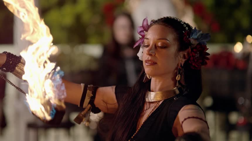 A woman turns twirling flaming torches as she performs a fire dance
