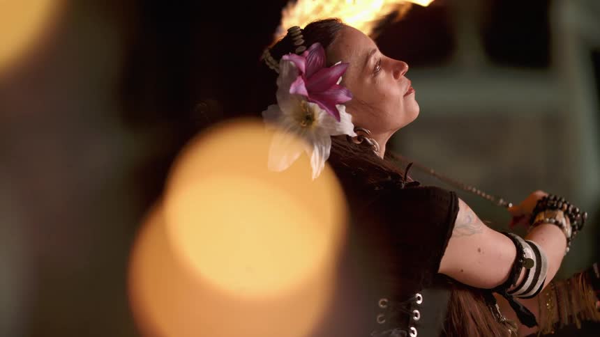 Woman swinging fire dancing props at night