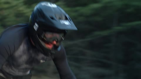 A man is riding a bike through a forest during spring