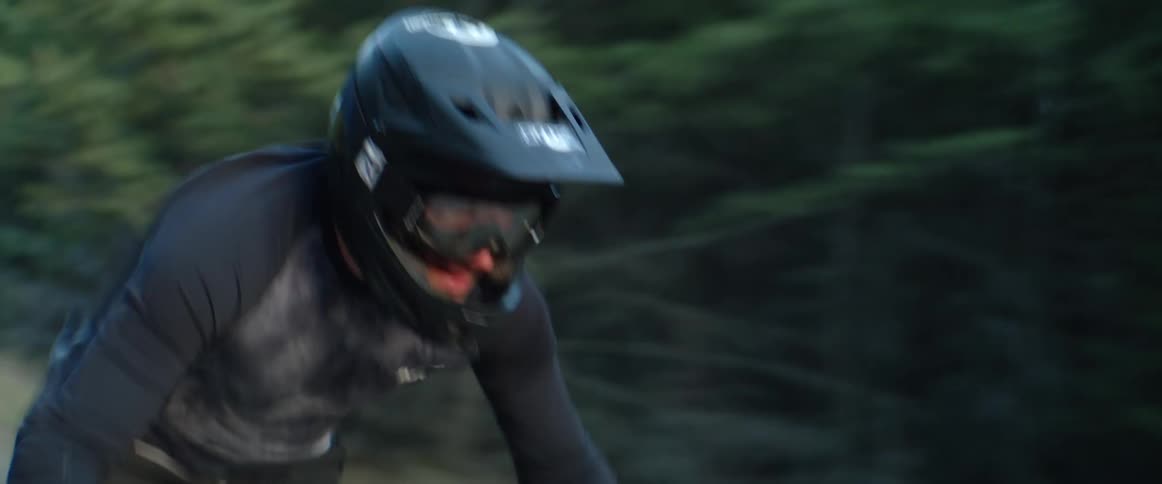 A man is riding a bike through a forest during spring