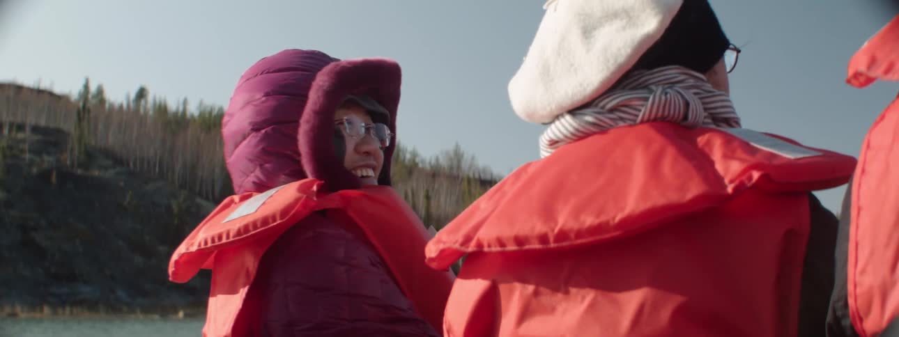 People standing on the shore with life jackets on