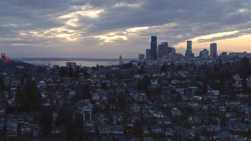 Flying along homes in the Leschi neighborhood with the Seattle skyline and Elliott Bay in the distance