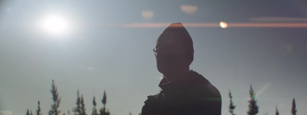 A man is hiking in a forest at dusk