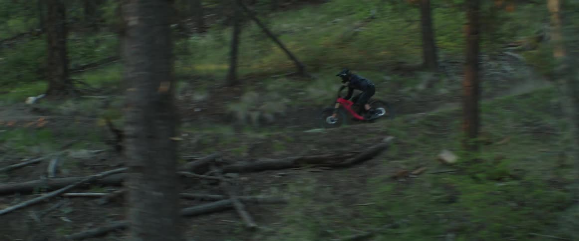 A mountain bike rider speeds through dusty corners in the forest