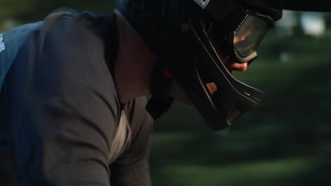 Cyclist wearing helmet and goggles pedals parts conifer forest
