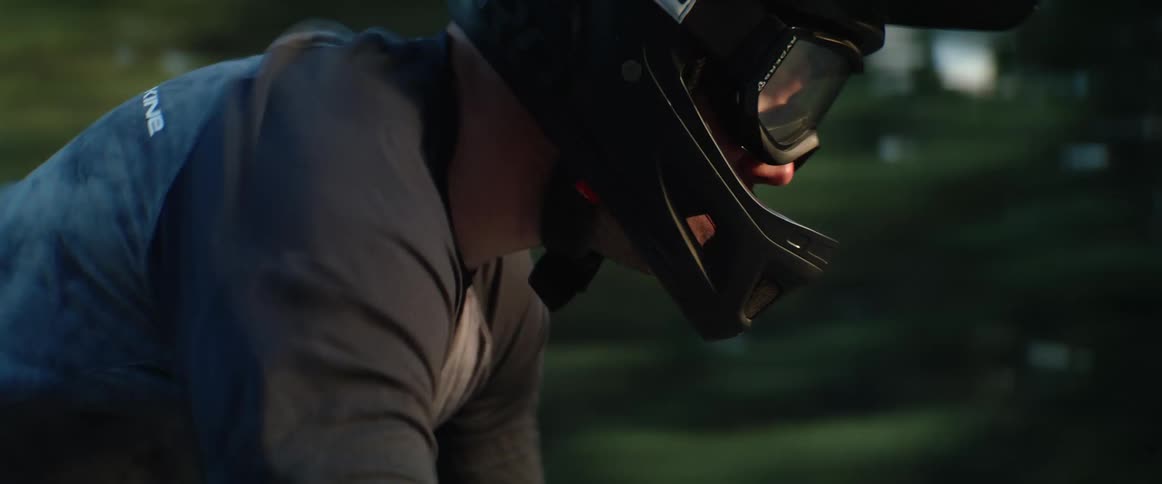 Cyclist wearing helmet and goggles pedals parts conifer forest