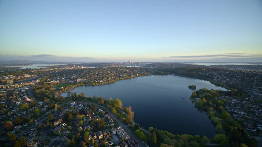 Wide pullback over Green Lake and the surrounding neighborhoods with downtown Seattle in the distance
