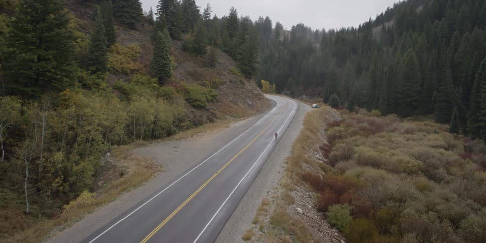 A person is riding a bicycle along a mountain road