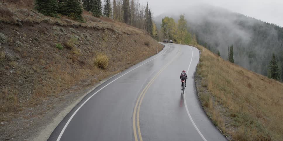 A person is riding a bike down a wet road