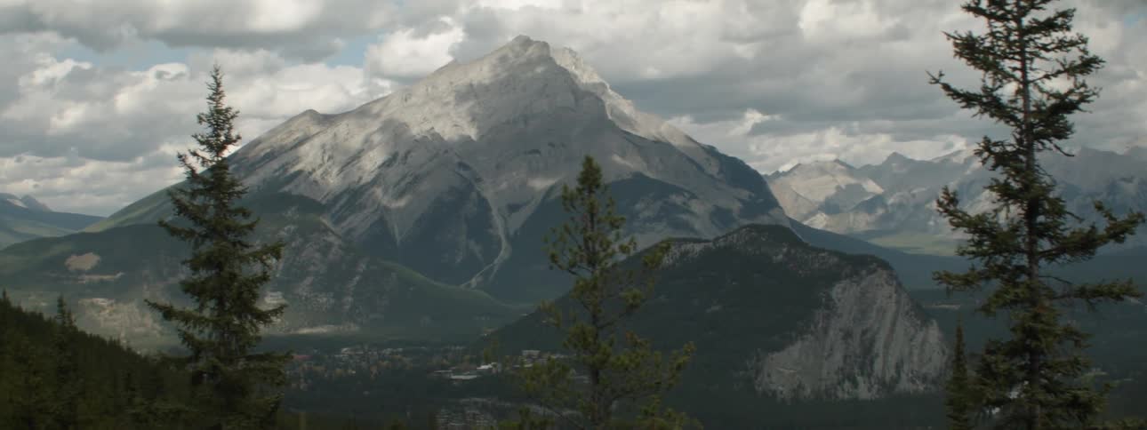A neighborhood sits on a slope at the base of a tall mountain