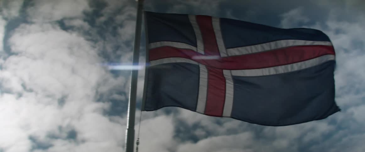 The icelandic flag blowing in the wind with the sky and clouds in the background