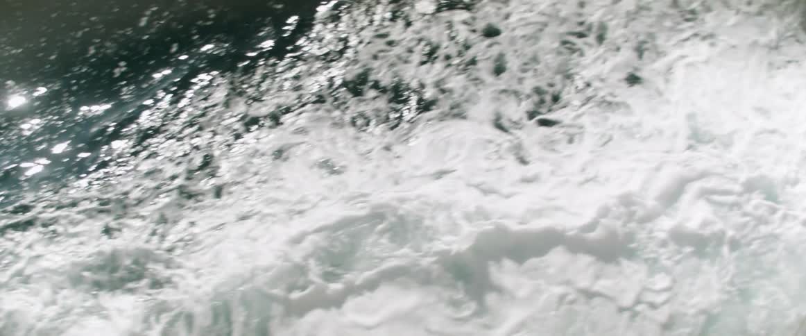 Light reflect from ocean water near foaming rolling waves