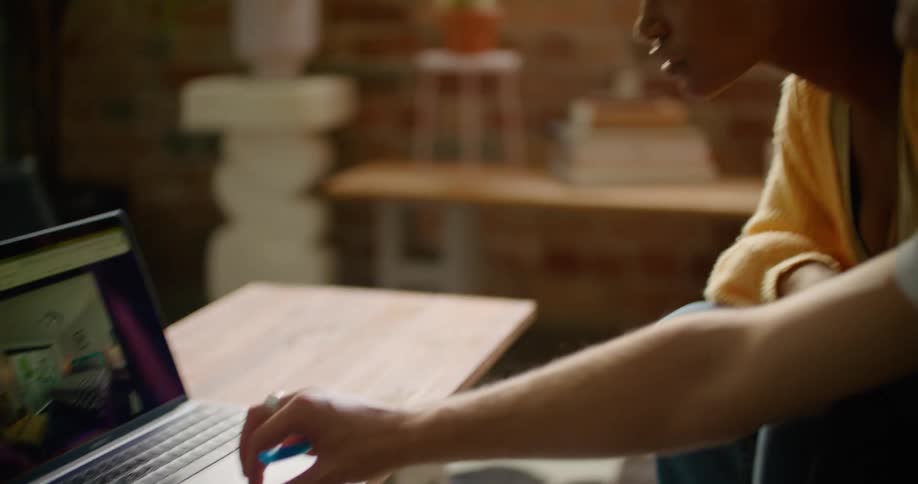 A man and woman are looking at a laptop together