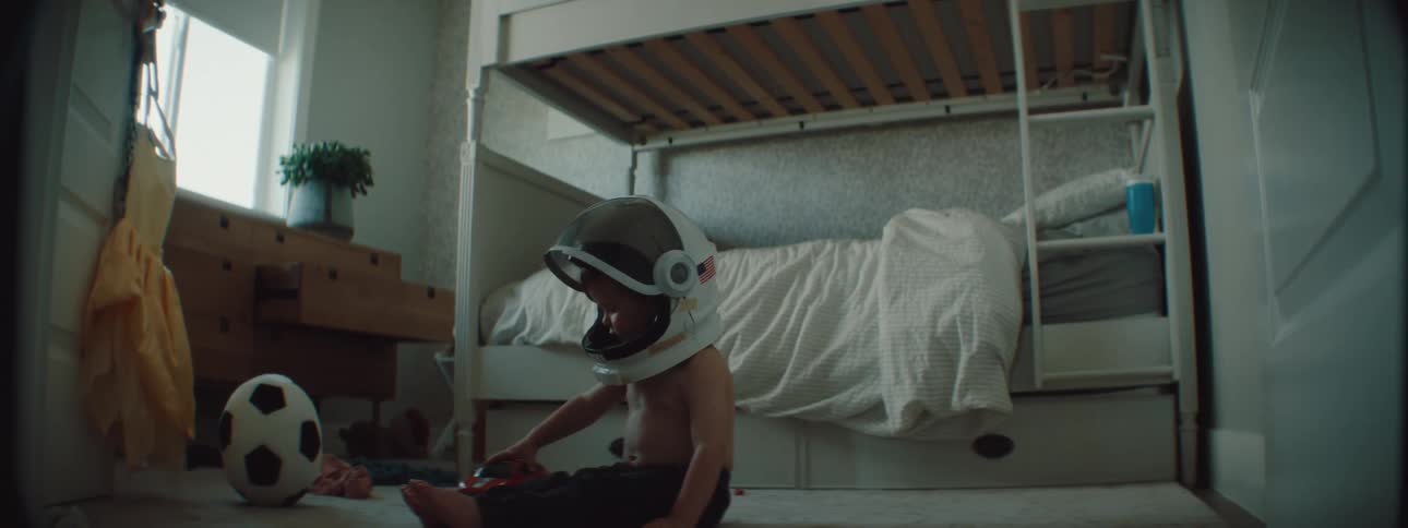 A child is sitting in his room and playing with toys