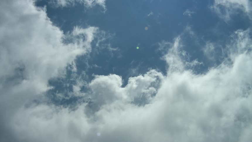 Wispy clouds move across a blue sky