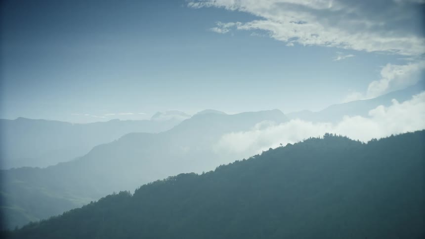 Mountain forest under a cloudy sky and mountains on the horizon