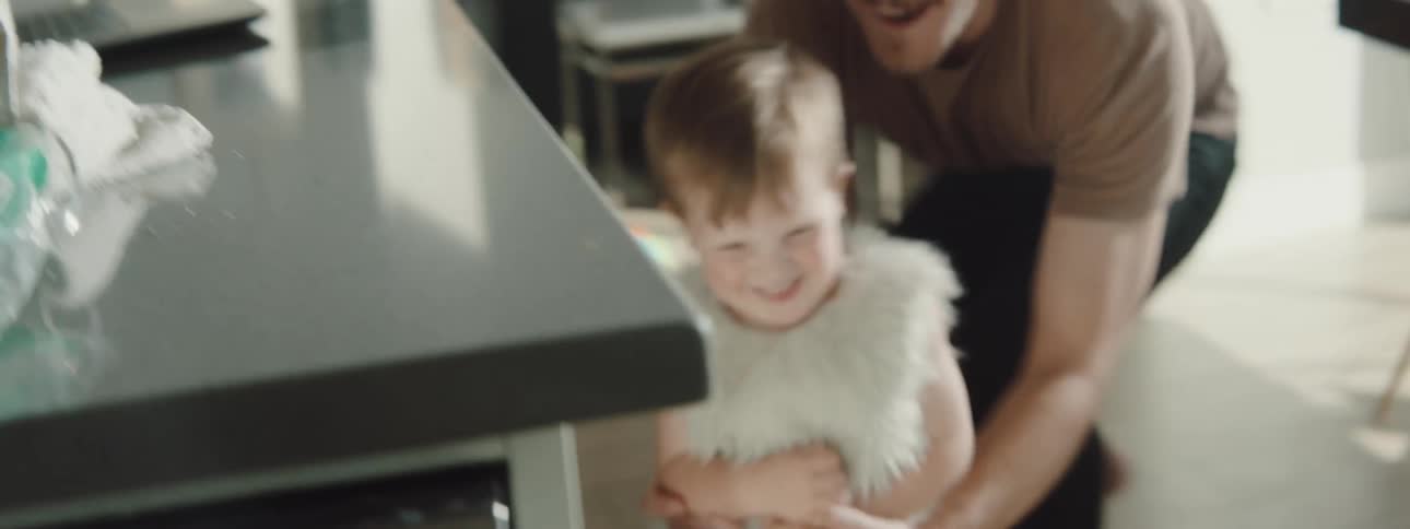A man playing with kids in his house