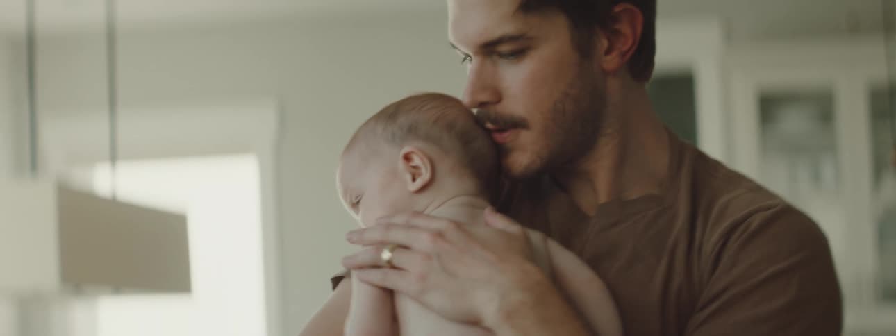 A man at home cuddles his fussy baby