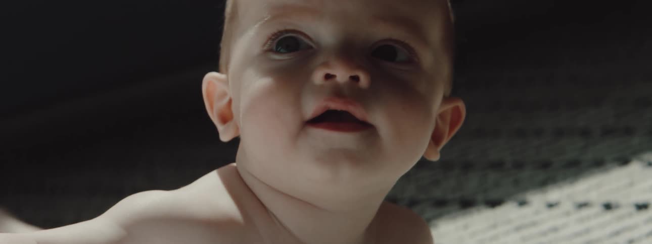 A baby is looking around and smiling
