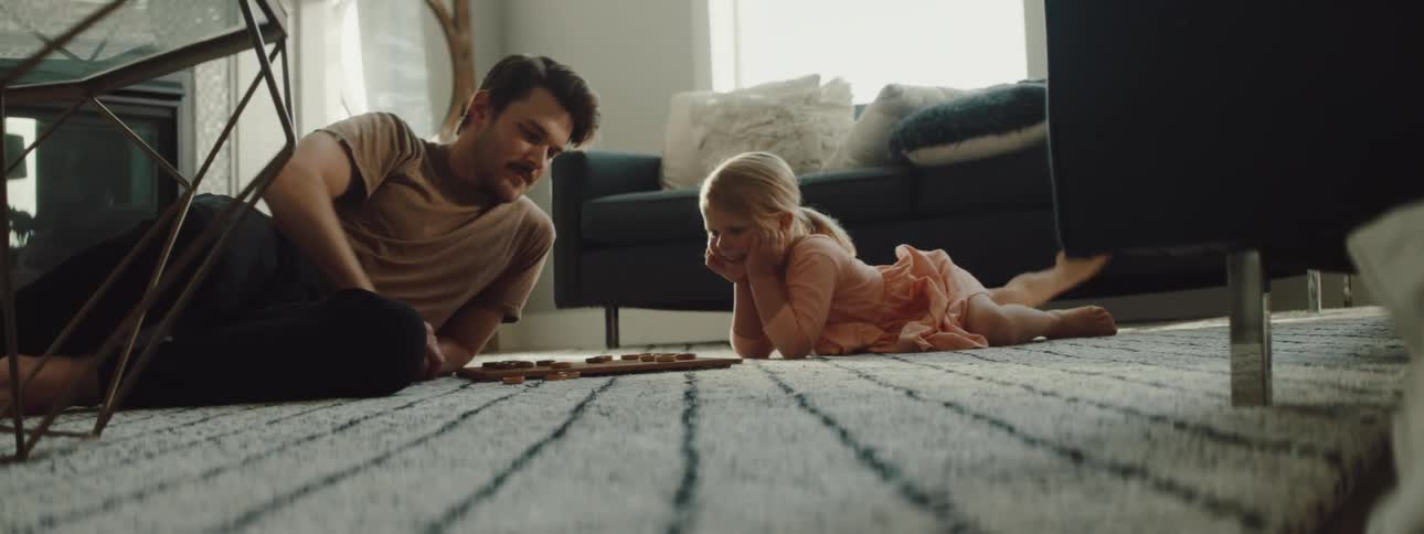 Father playing a board game with his daughter on the floor of the living room