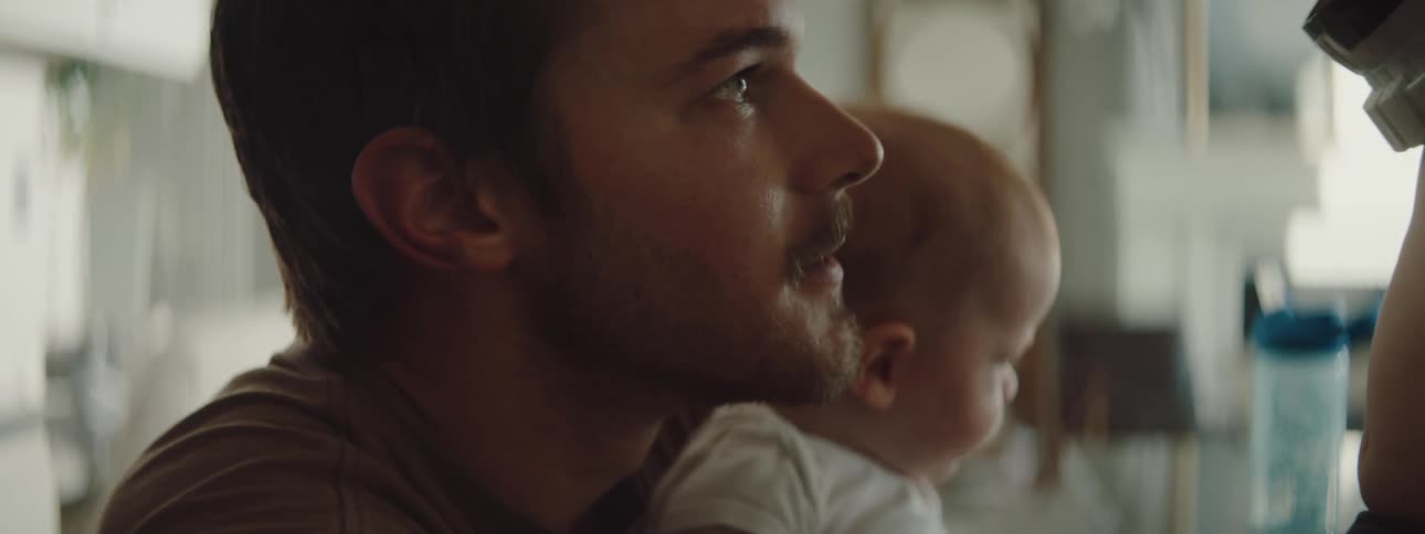 A father is talking to his son and daughter indoors