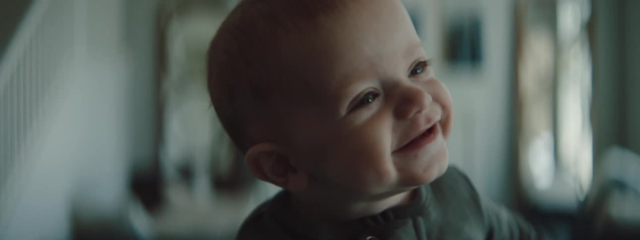 A baby smiling and laughing in a room in a house