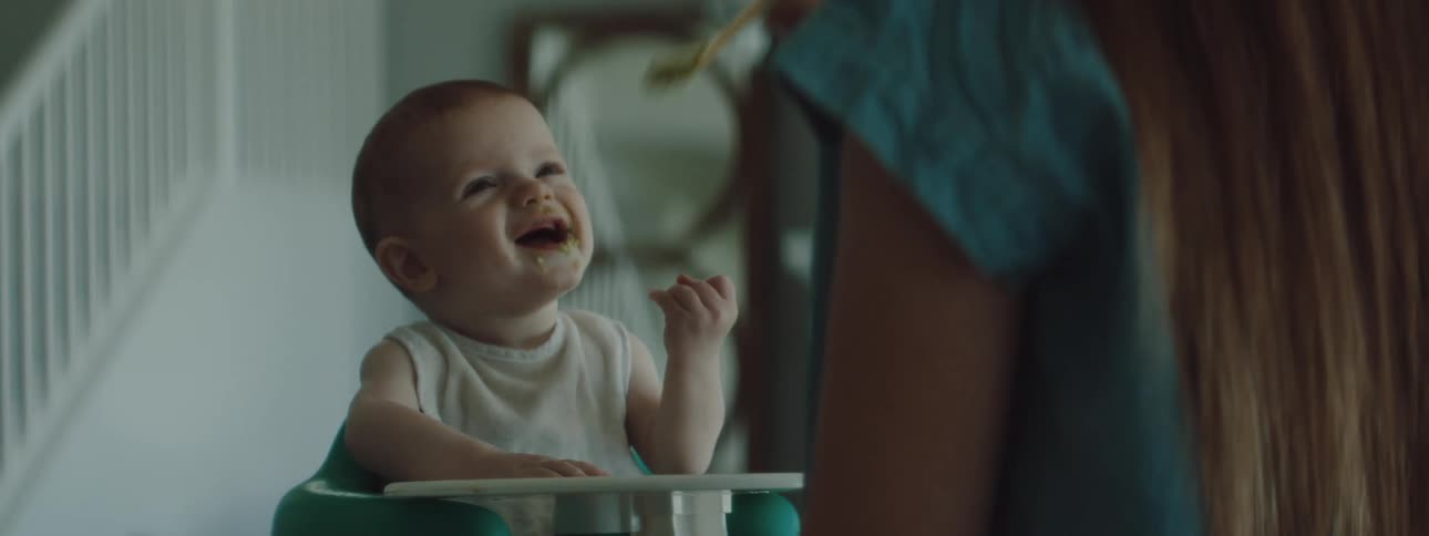 A mother is feeding her newborn baby food