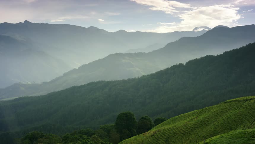 Aerial view of a landscape with mountains and hills is displayed at dusk