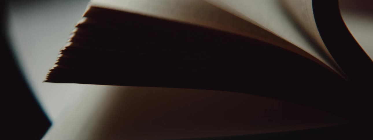 A person in a room flipping pages in a book