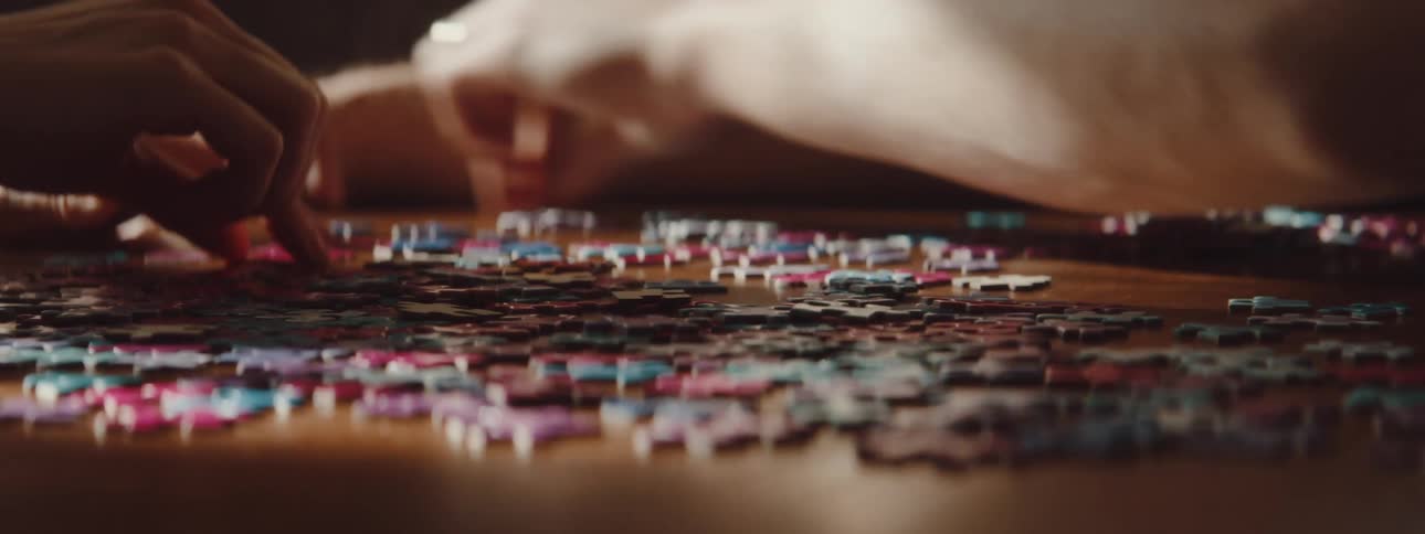A man and woman sort puzzle pieces